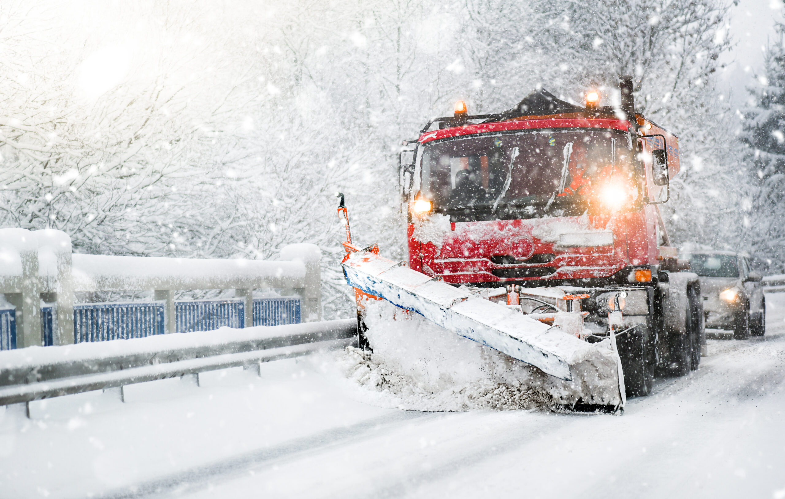 Snöröjning på gång. En av Bilfrakts snöplog-lastbilar röjer en snötäckt väg under kraftigt snöfall.